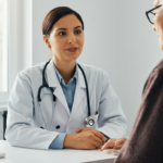 Physician using ambient voice AI during patient consultation in modern exam room